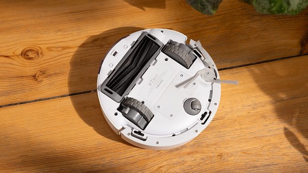 Top view of a SwitchBot K10 Pro robot vacuum cleaner on a wooden surface.