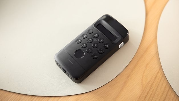 Ein schwarzes SwitchBot Ultra Touch Combo Schloss mit einer Tastatur auf einer hellen Oberfläche.