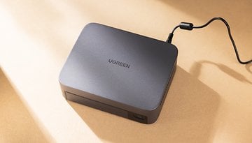 UGREEN Nasync DXP480T Plus-Gerät mit einem Stromkabel auf einer beigen Oberfläche.