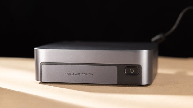 Gray external device with a power button and the text 'PROTECT WHAT YOU LOVE' on the front.