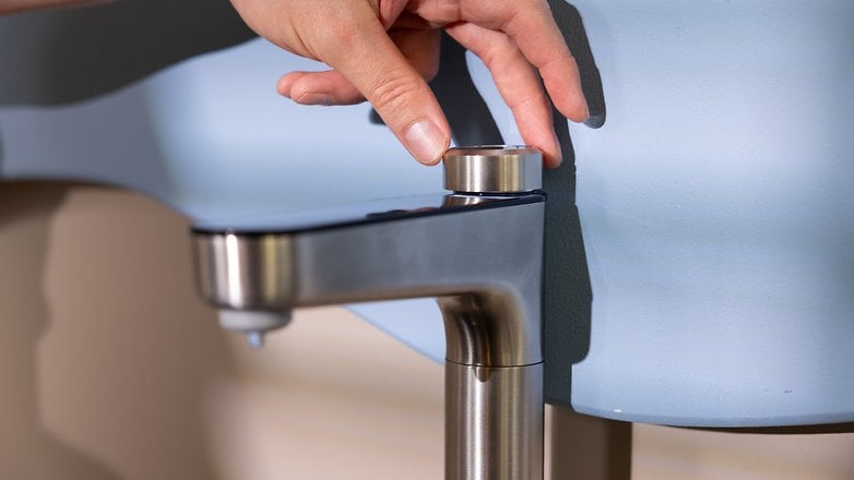 Eine Person, die einen modernen Wasserhahn mit elegantem Design anpasst.