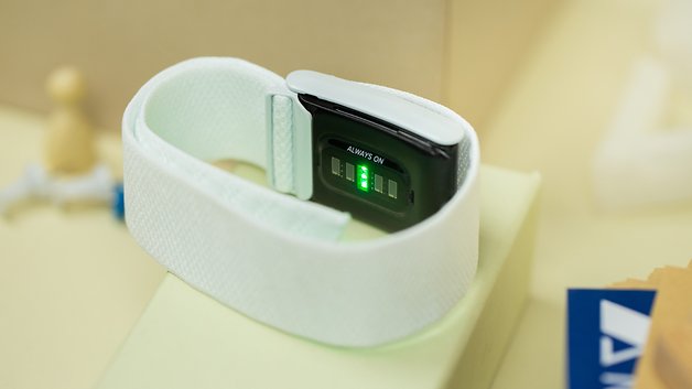 A white fitness tracker with a black display showing green lights and the text 'ALWAYS ON'.