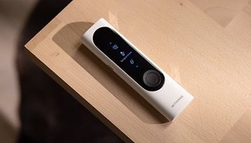 A Withings BeamO device displayed on a wooden surface, showing a temperature measurement screen.