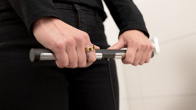 Person holding a device for body scanning in a bathroom.