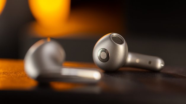 Écouteurs sans fil Xiaomi Buds 5 sur une surface texturée avec un arrière-plan flou.