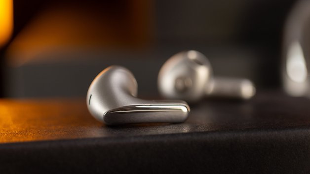 Gros plan des écouteurs sans fil Xiaomi Buds 5 sur une surface sombre.