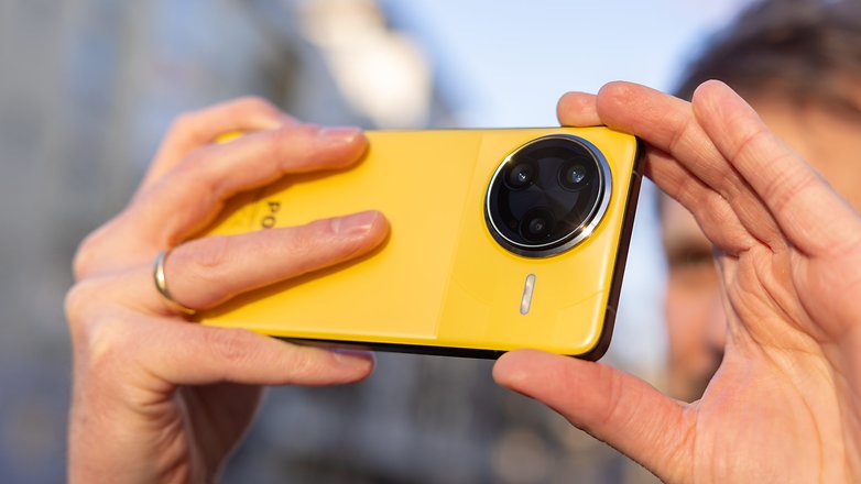 Une personne tient un smartphone Xiaomi F7 Ultra jaune, prête à prendre une photo.