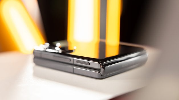 The Xiaomi Mix Flip when viewed from the side with a reflective surface and bright lights.