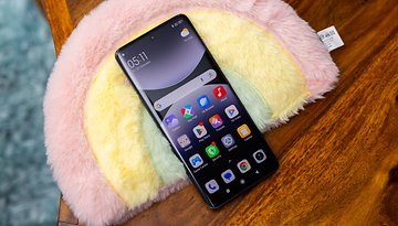 Xiaomi Redmi Note 14 Pro 5G Smartphone auf einer bunten Plüschoberfläche mit App-Icons.