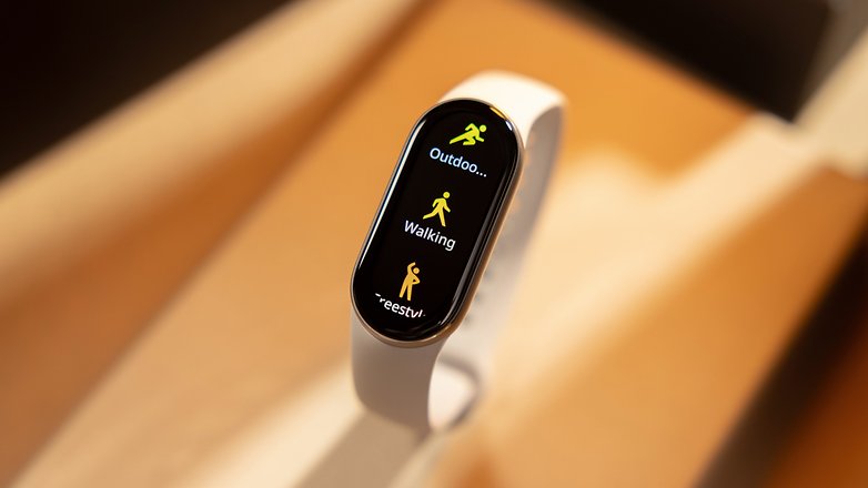 Xiaomi Smart Band 9 exibindo opções de atividade: Ao ar livre, Caminhada e um indicador de carregamento.