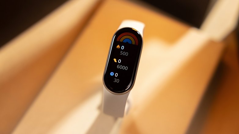 A Xiaomi Smart Band 9 displaying fitness statistics on its screen.