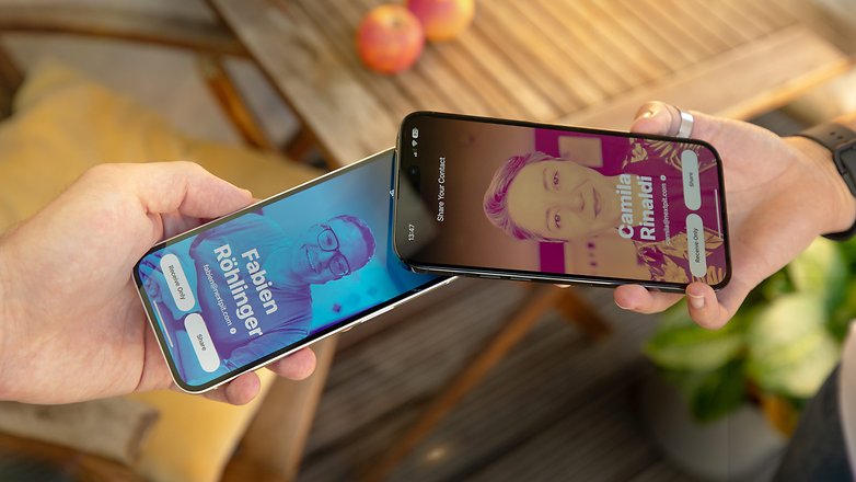 Dua orang bertukar poster kenalan menggunakan iPhone 14 dan iPhone 14 Pro Max