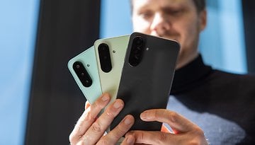 Una persona sosteniendo tres teléfonos inteligentes de la serie Samsung Galaxy A en diferentes colores.