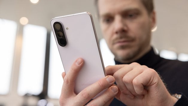 A person holds a Samsung Galaxy A56 smartphone and focuses on the device.