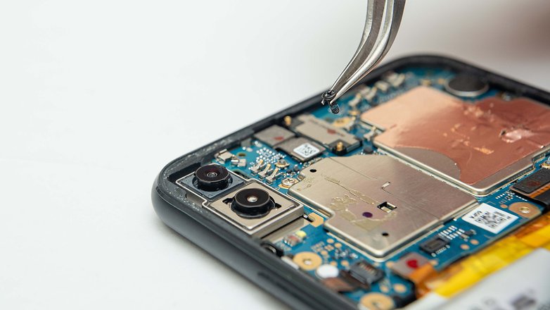 Ein Smartphone mit geöffneter Rückseite, das reparert wird.