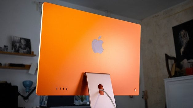 iMac M4 laranja visto de trás com o logotipo da Apple na parte traseira.