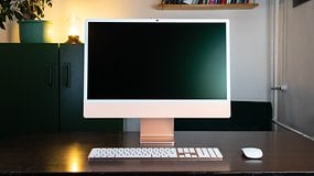 Un élégant Apple iMac M4 2024 sur un bureau en bois, avec un écran vide, un clavier et une souris.