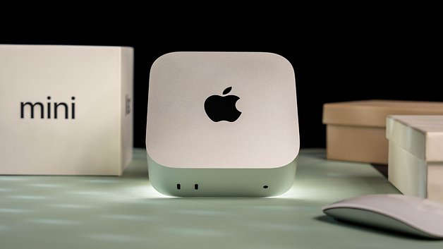 Mac Mini M4 2024 sobre uma superfície com um mouse e caixas ao fundo.