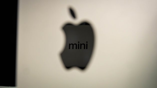 Close-up of an Apple logo with the word 'mini' on a Mac Mini device.