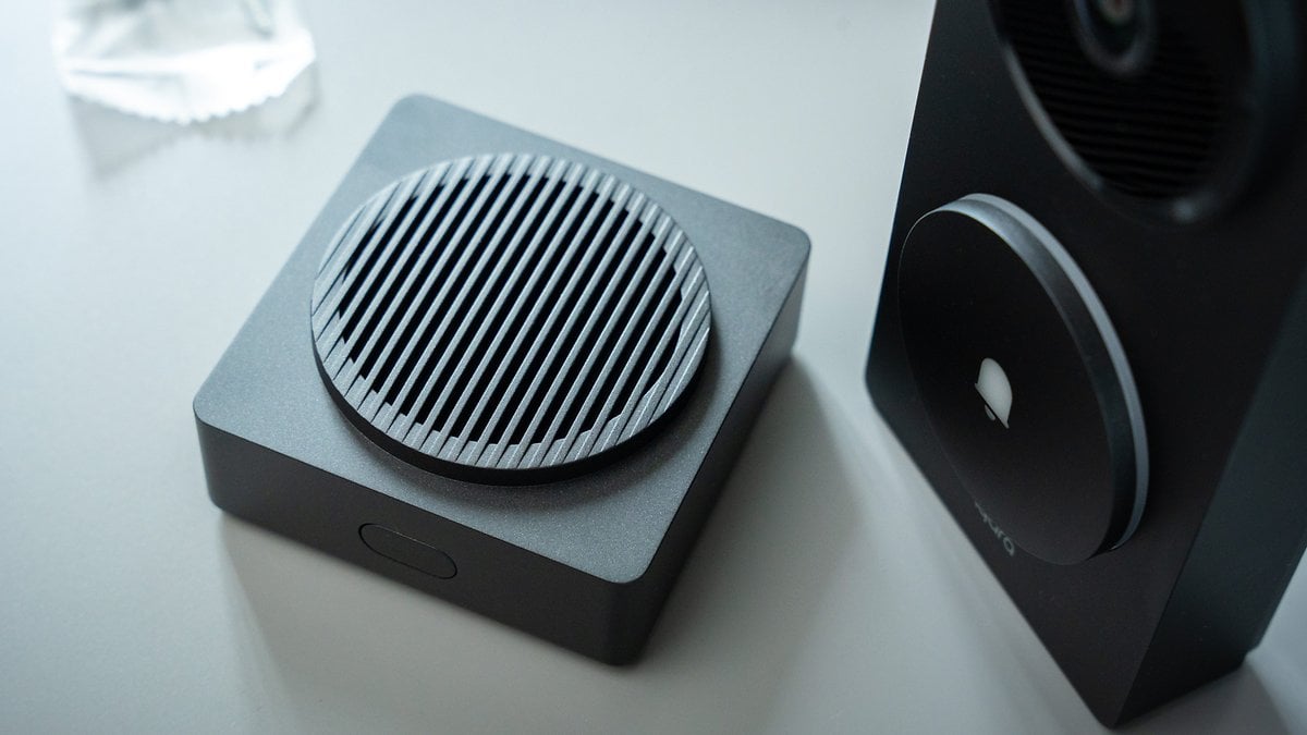 Gros plan sur le hub de la caméra de porte Aqara G410, avec un haut-parleur rond strié et un design noir.
