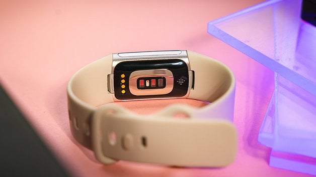 Back view of a Fitbit Charge 6 smartwatch on a pink surface.