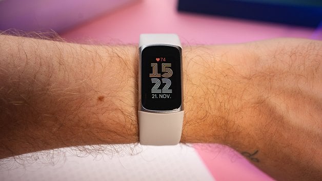 A person's wrist displaying a Fitbit Charge 6 with the date 21 NOV and time 15:22.