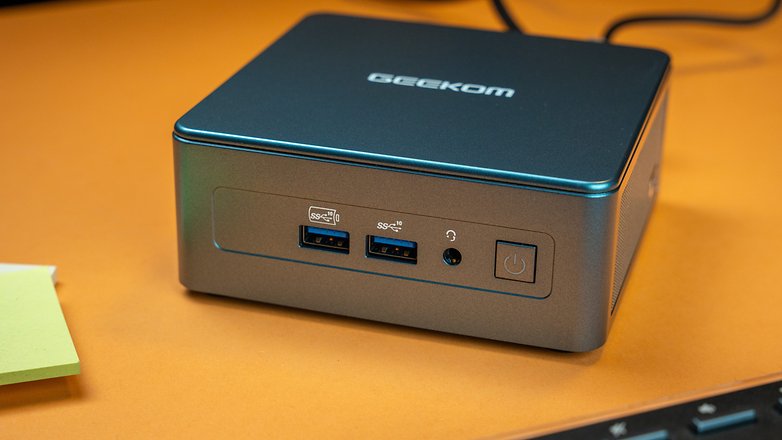Geekom Mini IT 13 front side with two USB-A ports, a headphone jack, and power button.