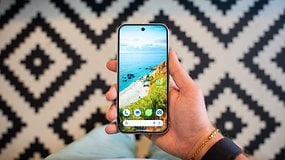 Une main tenant un smartphone Google Pixel 9 affichant un fond d'écran de plage.