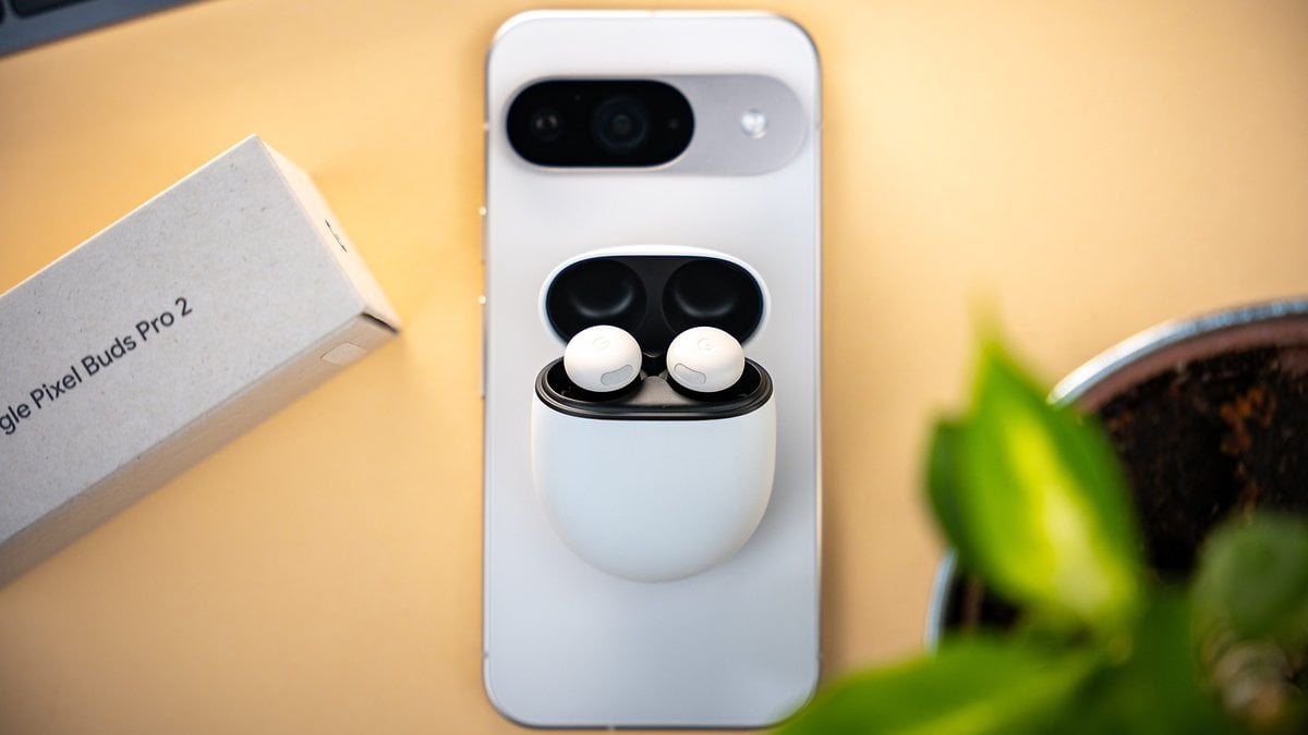 Une paire de Google Pixel Buds Pro 2 dans leur étui sur un smartphone avec une boîte à côté.