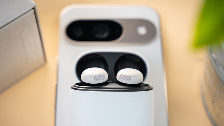 A close-up of Google Pixel Buds Pro 2 in their charging case on a wooden surface.