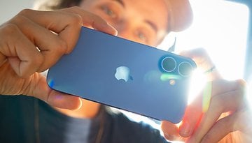 Une personne tenant un Apple iPhone 16, mettant en valeur sa couleur bleue et sa double caméra.