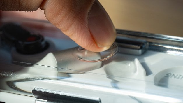 A finger fidgeting with the Nothing Ear (one) earbuds.