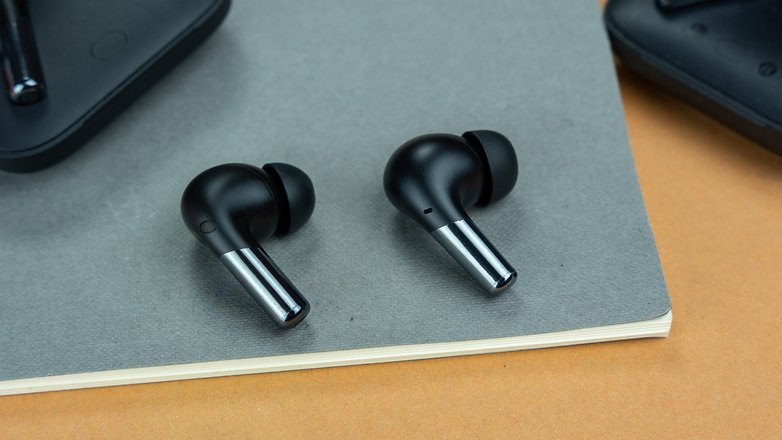 Les deux OnePlus Buds Pro 2 posés sur une feuille Canson verte foncée