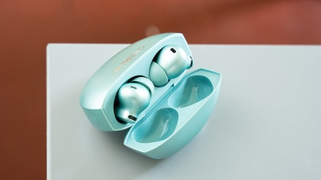 Offene hellblaue Ladehülle mit zwei OnePlus Buds darin.
