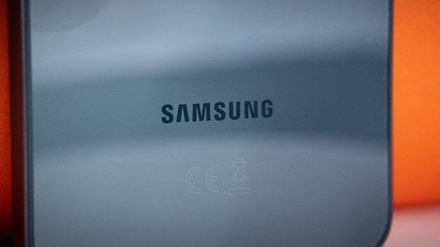 Logotipo da Samsung na parte traseira de um smartphone contra um fundo laranja.