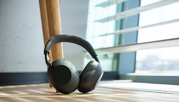 Ein Paar Sony WH-1000XM6 Kopfhörer liegt auf einem Holzboden neben einem Fenster.