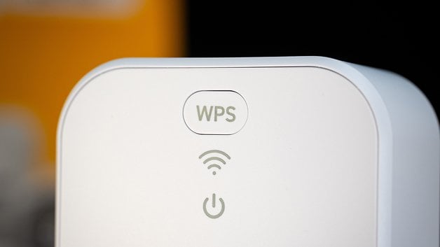 Nahaufnahme eines weißen Geräts mit WPS- und WLAN-Symbolen sowie einem Netzschalter.