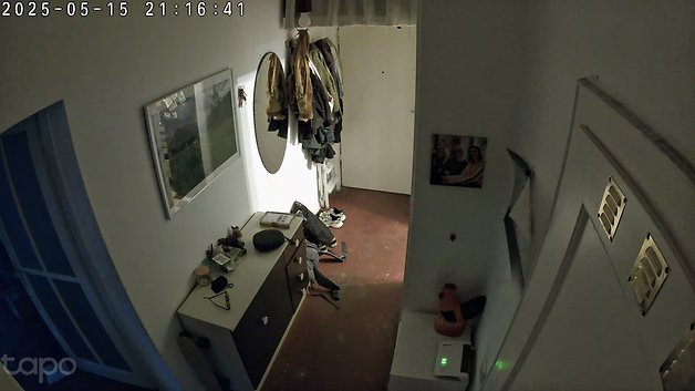 Ein Flur mit einem Spiegel, Kleidung an Haken und einer Kommode mit verschiedenen Gegenständen.