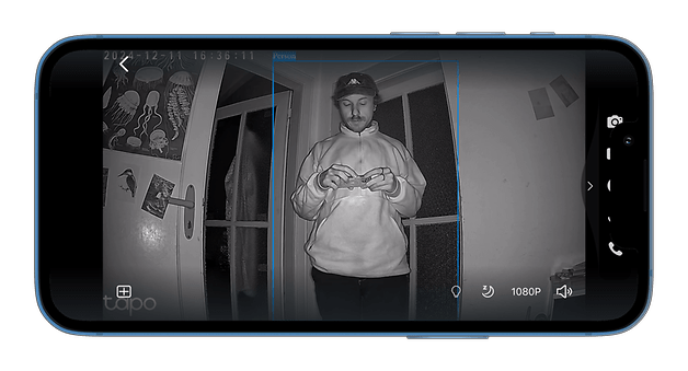 A smartphone screen shows a dark image from a Tapo C501GW camera depicting a person near a door.