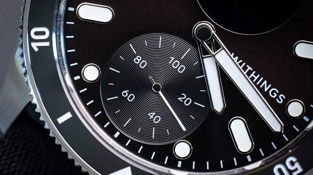 Nahaufnahme des schwarzen Zifferblatts und der silbernen Zeiger der Withings ScanWatch Nova.