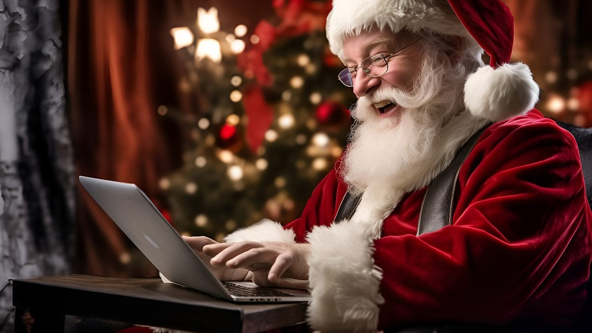 Santa Claus writes Christmas greetings on his notebook