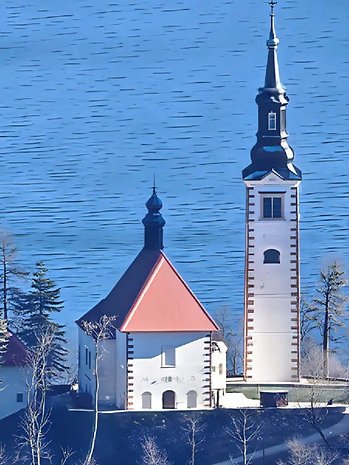 Vista de uma igreja com um campanário ao lado de um lago azul.