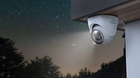 Überwachungskamera an Häuserwand, im Hintergrund Nachthimmel