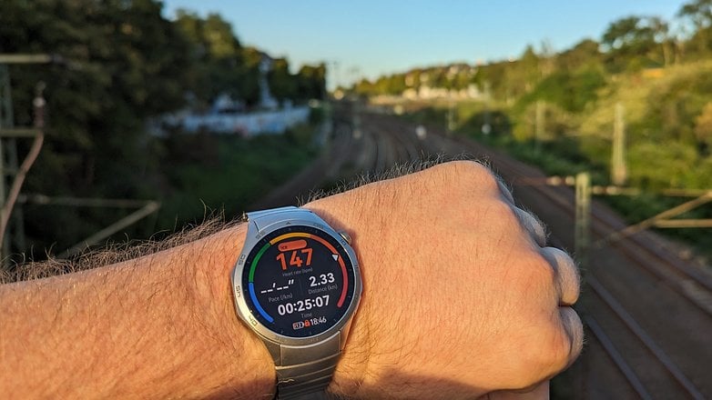 Huawei Watch GT 4 an meinem Arm mit Gleisen im Hintergrund