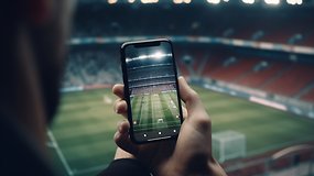 Jemand filmt ein Sport-Event im Stadion mit seinem Handy