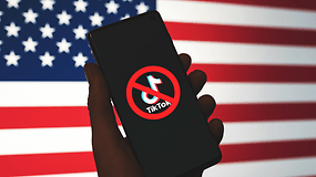 ein durchgestrichenes TikTok-Logo auf einem Smartphone vor US-Flagge