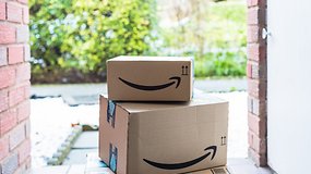 Amazon-Pakete liegen vor einer offenen Haustür auf der Matte