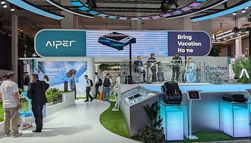 AIPER-Messe-Stand mit dem Slogan 'Bring Vacation Home' und einer Band, die auftritt.