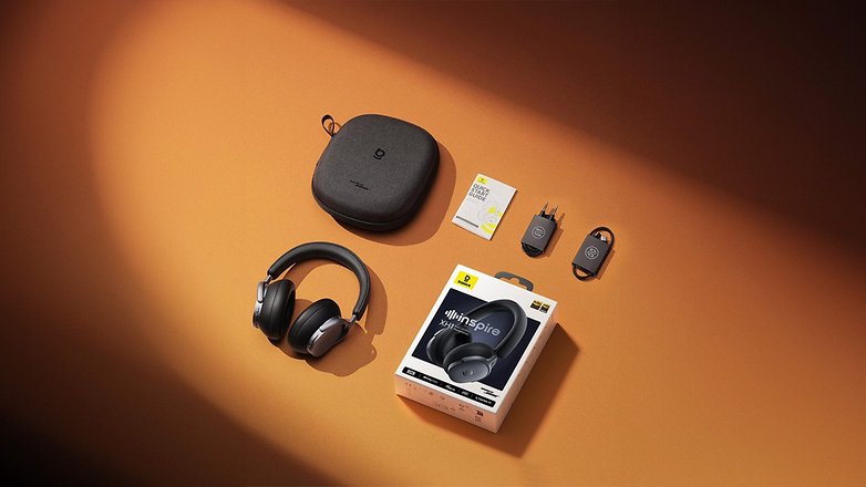Baseus Inspire XH1 Over-Ear-Kopfhörer mit Zubehör und Verpackung auf orangefarbenem Hintergrund.
