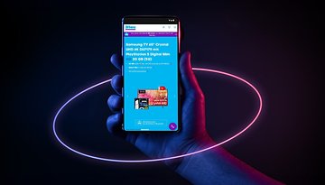Eine Hand hält ein Smartphone, das ein Angebot für ein Samsung TV und PlayStation 5 Bundle von Blau zeigt.